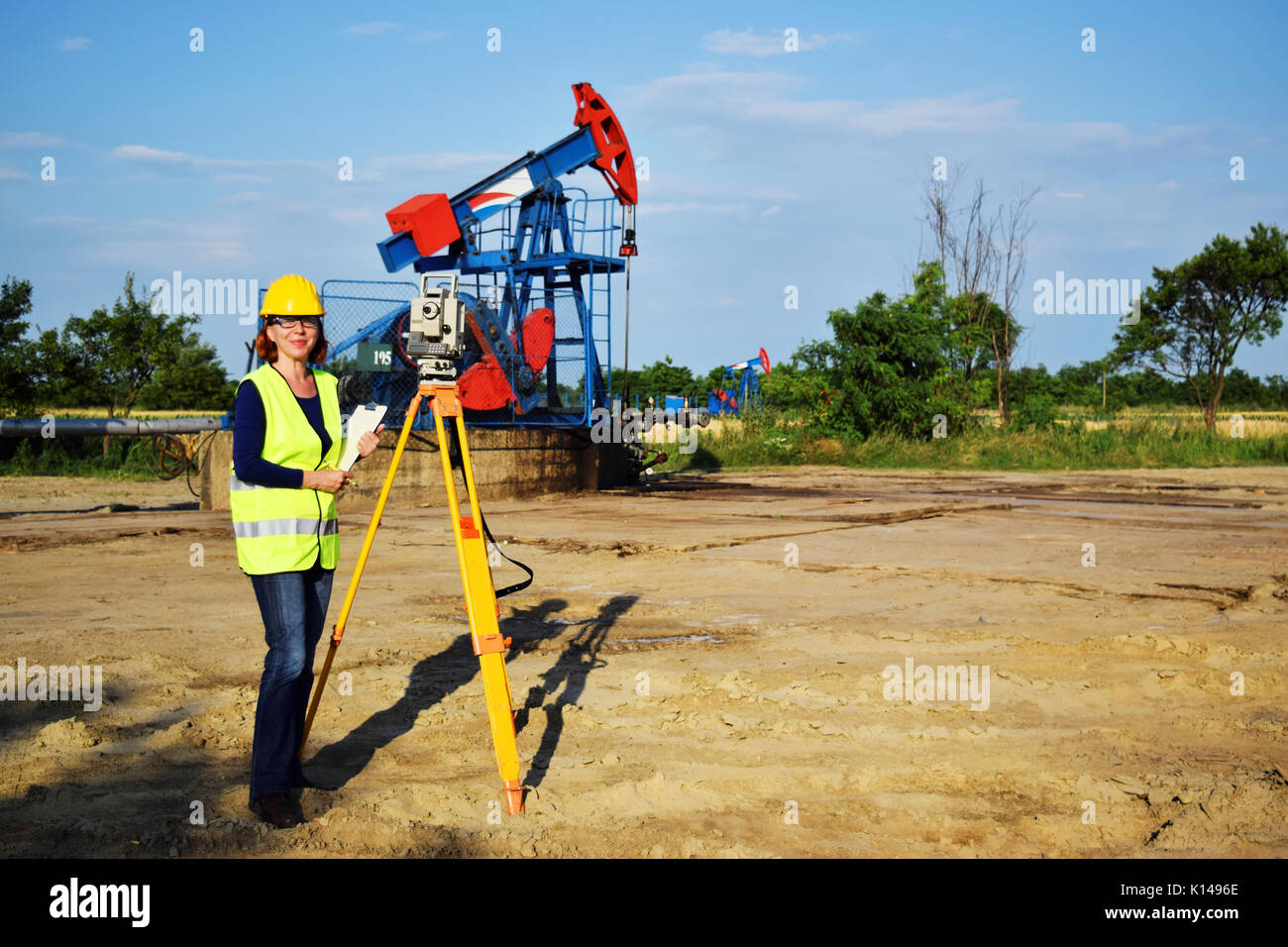 Surveyor bei der Arbeit und Erdöl Pumpe im Hintergrund Stockfoto