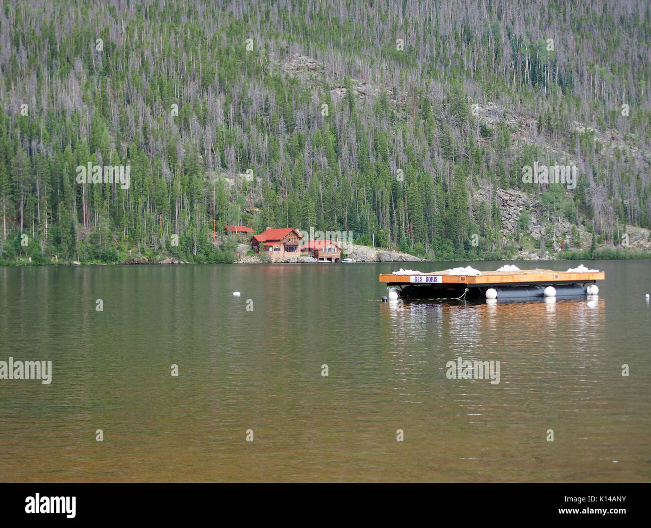 Grand Lake, Co - 11. August: Ein eigenes Dock schwimmt in Grand Lake. Es ist ein luxuriöses Haus am See mit den Rocky Mountains, die sich dahinter. Stockfoto