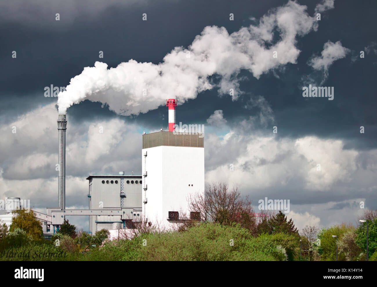 Wasserkraftwerk emitting weissen Dampf vor einem dunklen grauen Wolke Stockfoto