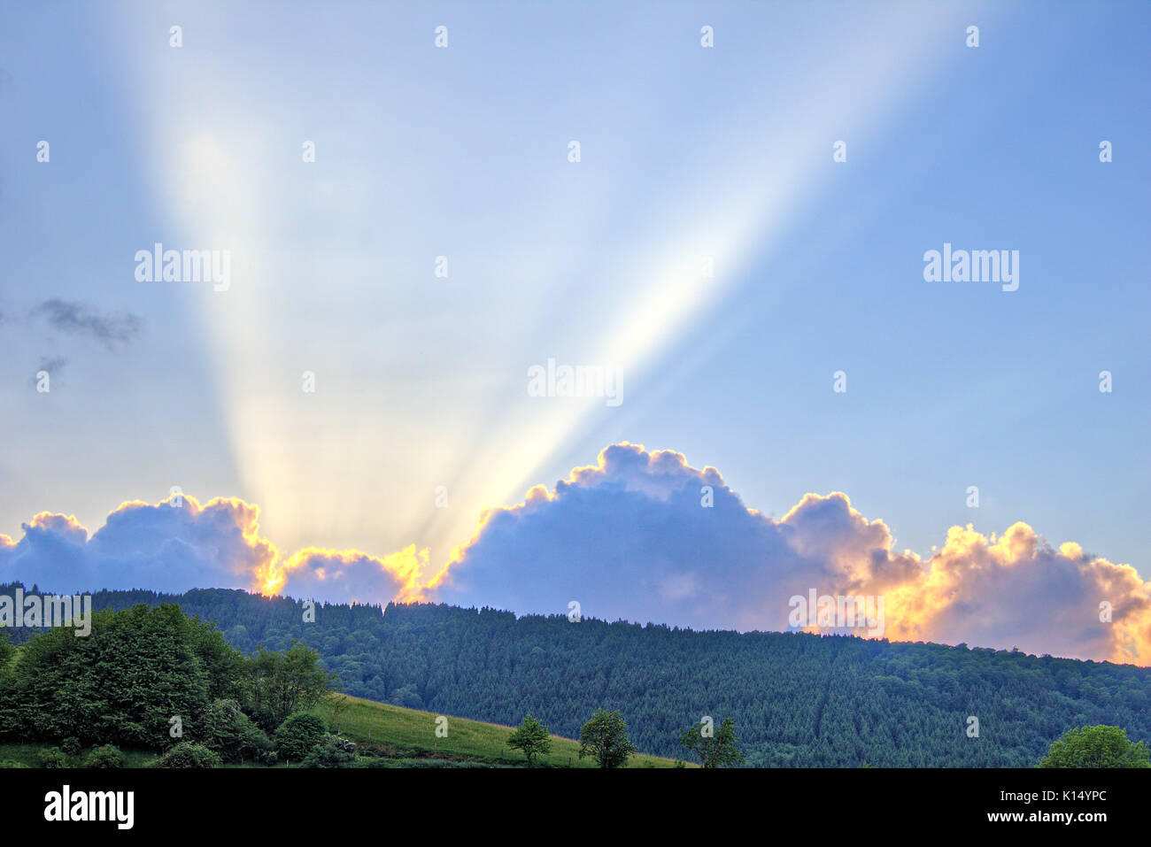 Sonnenuntergang mit Strahlen des Lichtes über die bewaldeten Bergrücken Stockfoto
