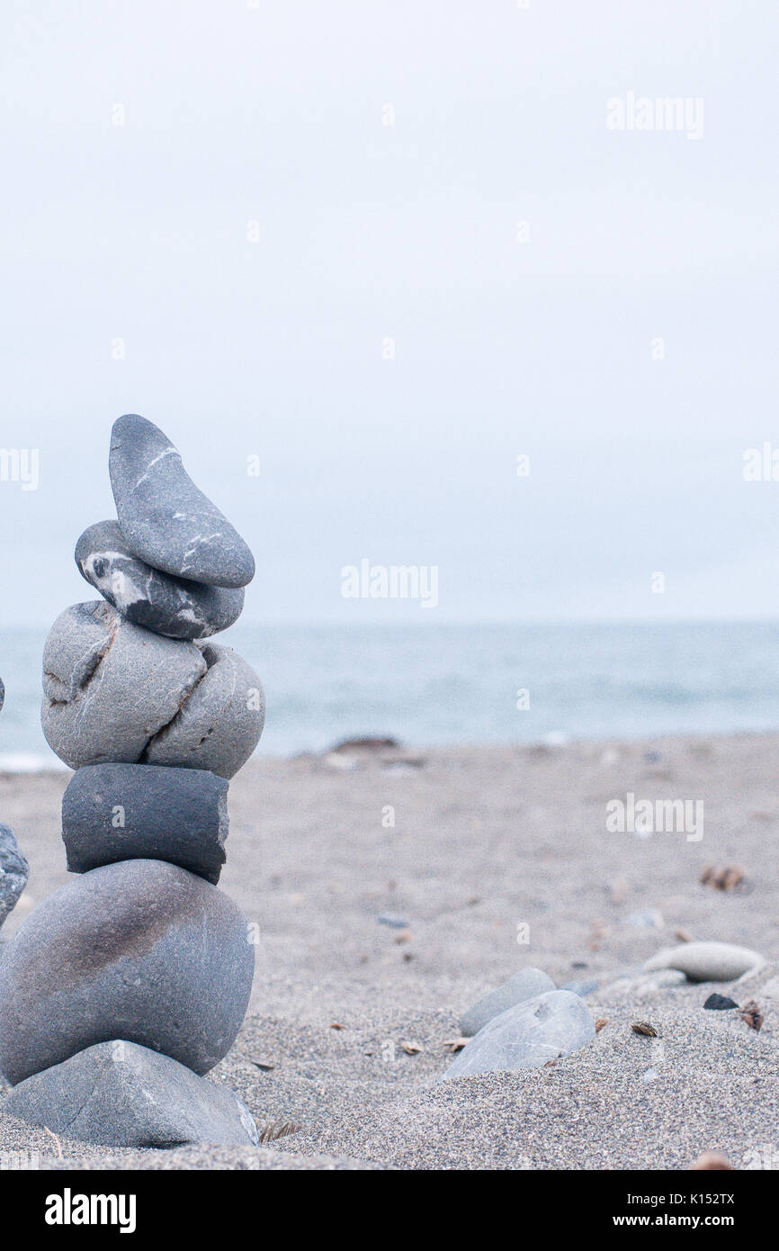 Monochrom, ruhigen, blauen gestapelte Steine auf einem Kalifornischen Strand als Symbol für Frieden, Gleichgewicht, Meditation und Achtsamkeit Stockfoto