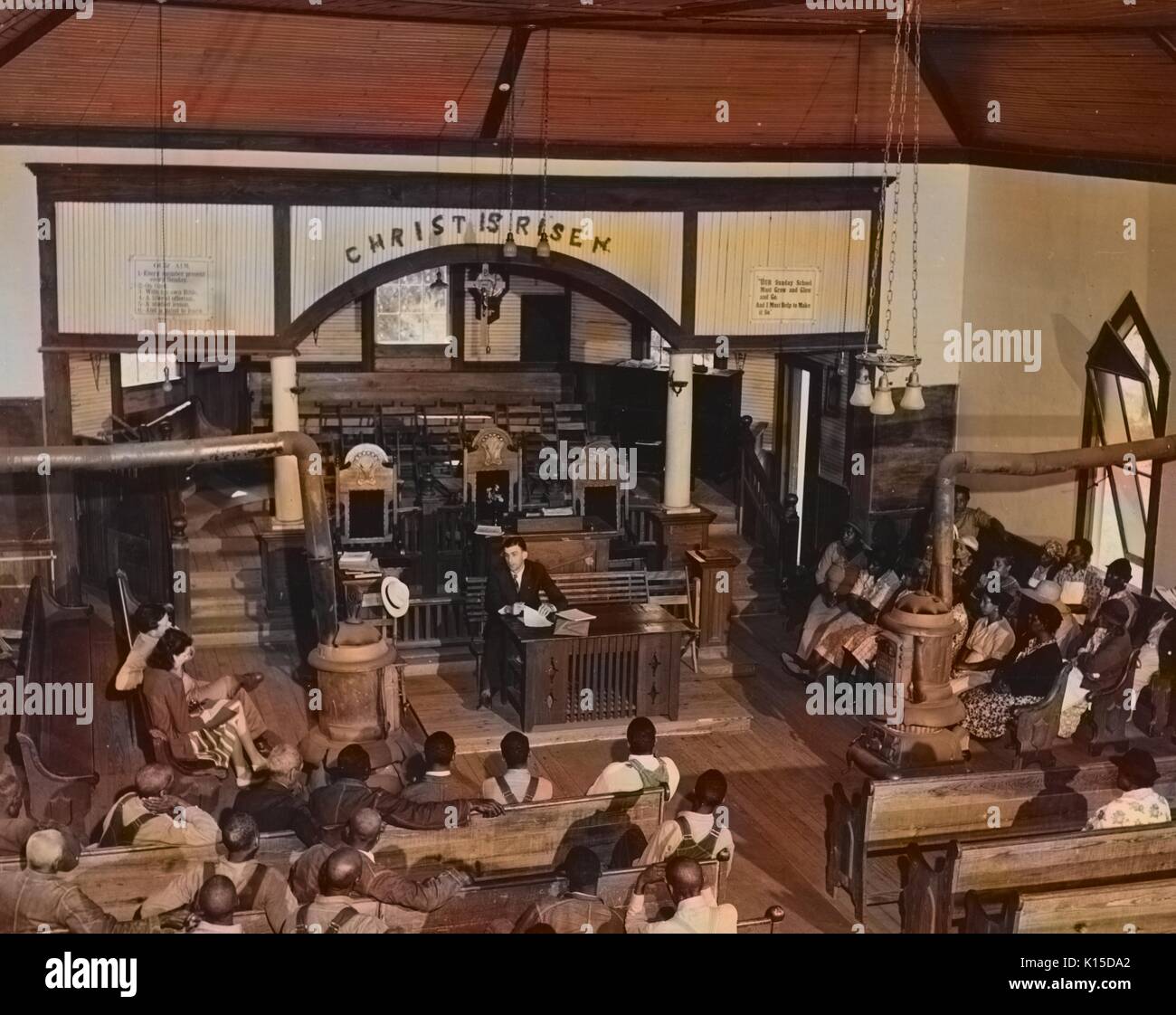 Afrikaner - Farm Security Administration Kreditnehmer in der Kirche sitzen und zuhören zu einem offiziellen, mit einer Meldung über dem Altar Christus ist auferstanden, 1920. Von der New York Public Library. Hinweis: Das Bild hat digital über ein modernes Prozess eingefärbt worden. Farben möglicherweise nicht sein - genau. Stockfoto