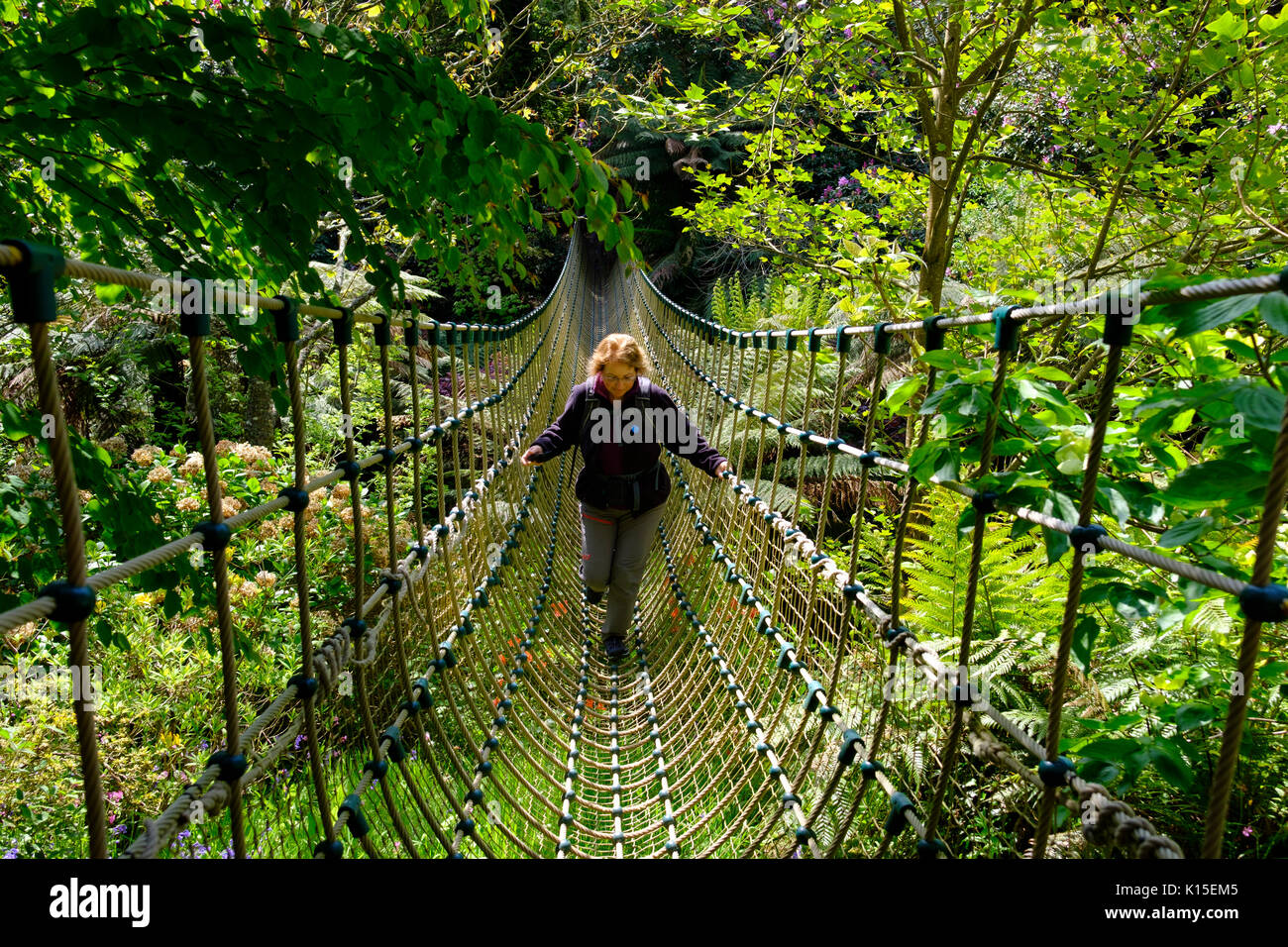 Frau auf Birma Suspension Bridge in der Dschungel, die Verlorenen Gärten von Heligan, in der Nähe von St Austell, Cornwall, England, Vereinigtes Königreich Stockfoto