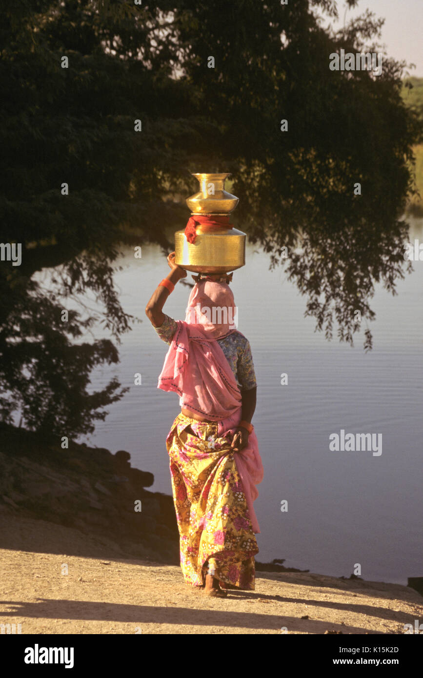 Bishnoi Frau Füllung messing Töpfe mit Wasser im See, Rohet, Rajasthan, Indien Stockfoto