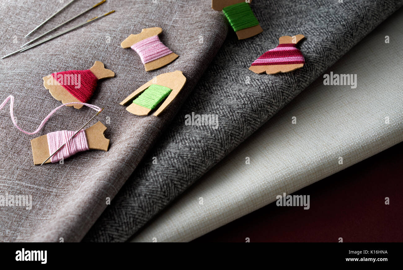 Nadeln, Gewinde und Kraftpapier Karte Bobbin auf Stoff Stoff Hintergrund Stockfoto