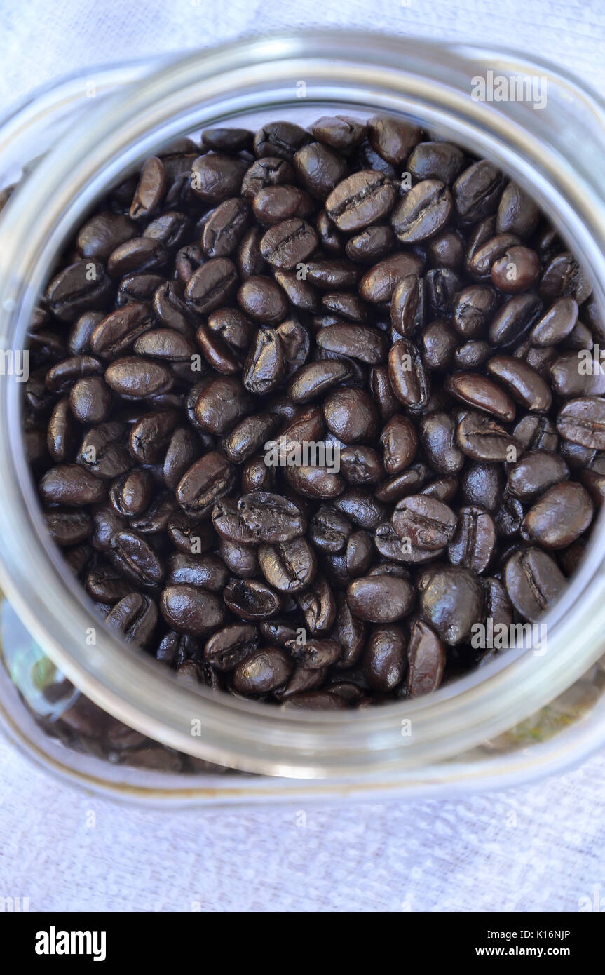 Dunkel geröstete Kaffeebohnen in Glas Glas Stockfoto