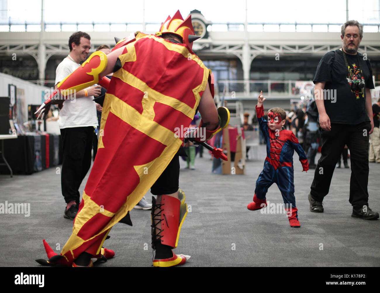 3 Jahr alten Finn Stewart gekleidet wie Spiderman trifft Michael Whicelo wie Pokemon Primal Groudon an der London Super Comic Con, im Business Design Centre in London. Stockfoto