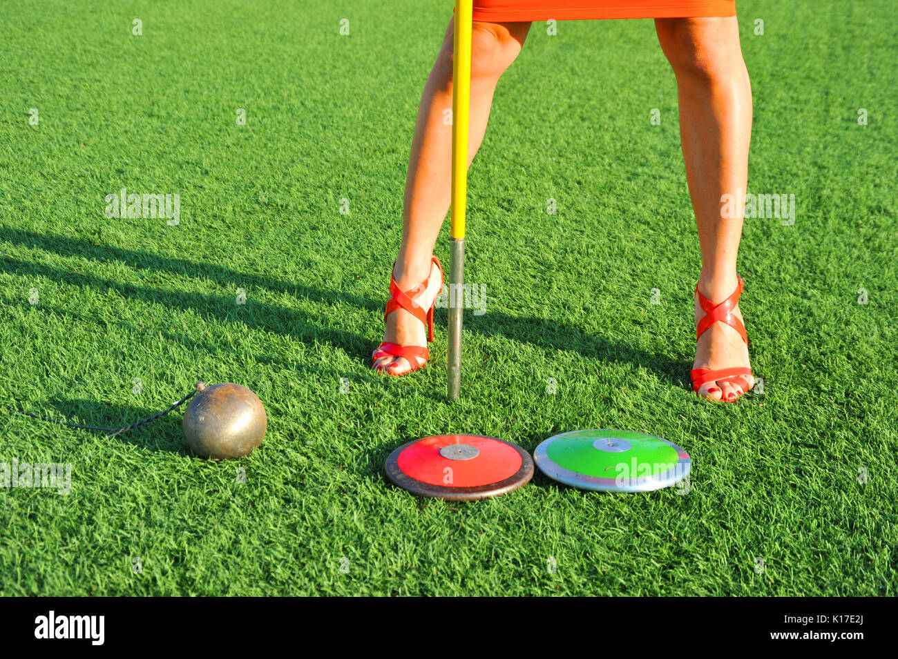 Mädchen mit hochhackigen Schuhe und athletische Gang, Diskus, Speer und Hammer. Stockfoto