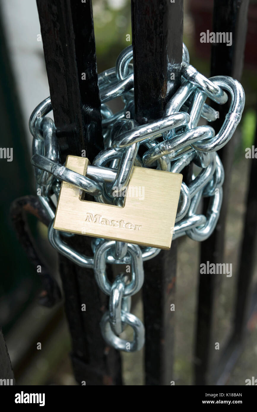 Schwere Metallkette, klopfte um Tor und mit einem Vorhängeschloss zu sichern. Kette und Vorhängeschloss. Stockfoto