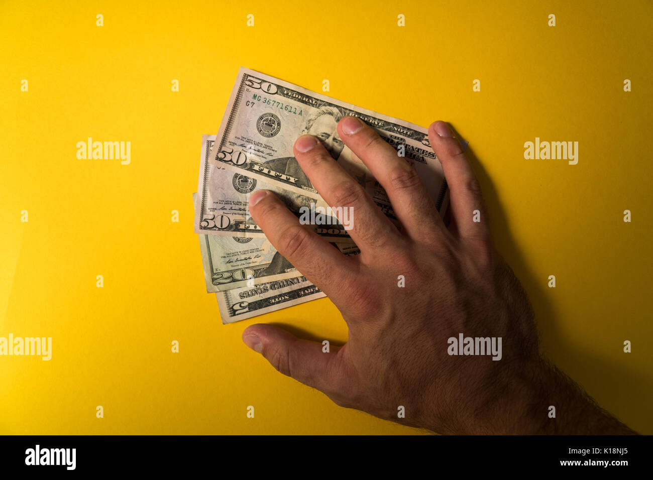 Die Hand des Mannes, die Dollar Banknoten abgedeckt. Schützen Sie Ihr Geld. Der Mangel an Geld. Dollar Banknoten Nahaufnahme. Stockfoto