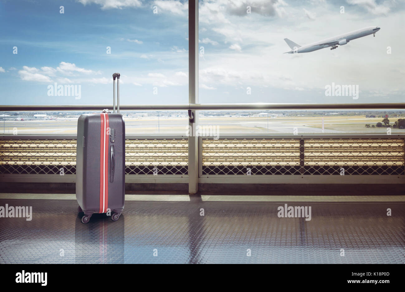 Koffer im Flughafen Abflughalle, Flugzeug im Hintergrund, Sommerurlaub Konzept, traveler Koffer im Flughafen Terminal warten. Stockfoto