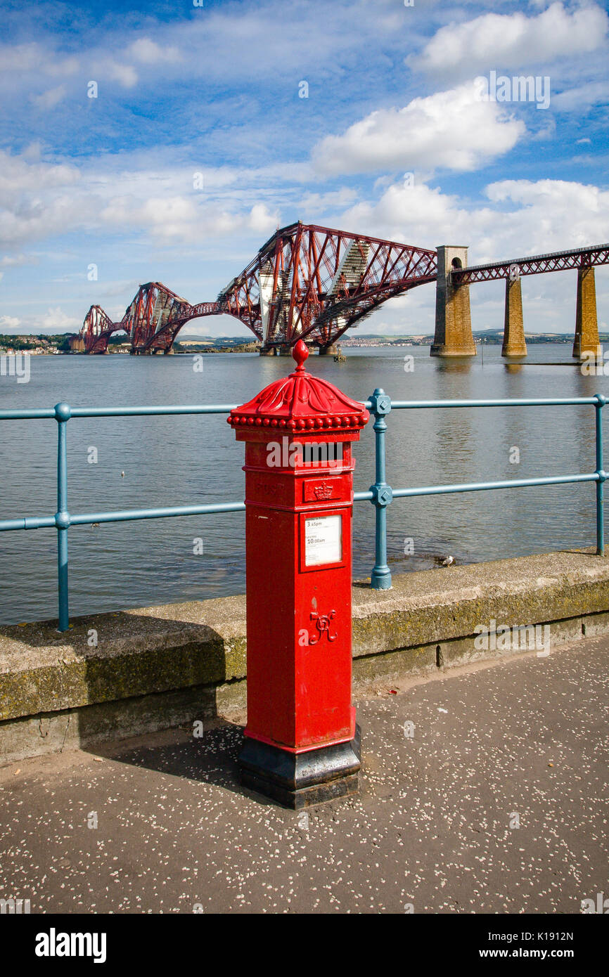 Red Royal Mail Post Box am Ufer des Firth-of-Forth mit der Forth Rail Bridge im Hintergrund in South Queensferry Edinburgh Stockfoto