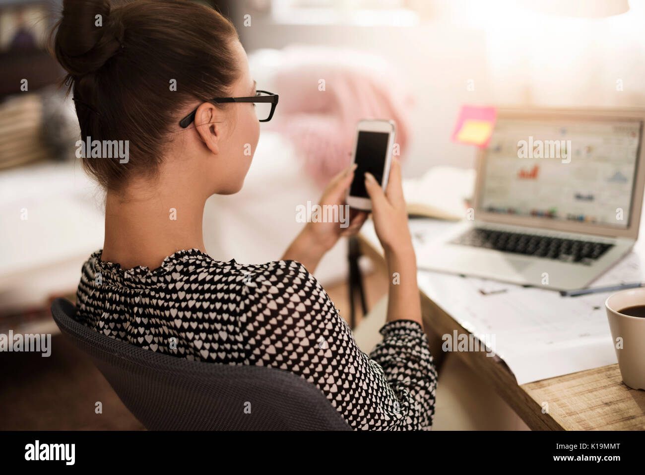 Text Messaging Frau vor ihrem Laptop Stockfoto