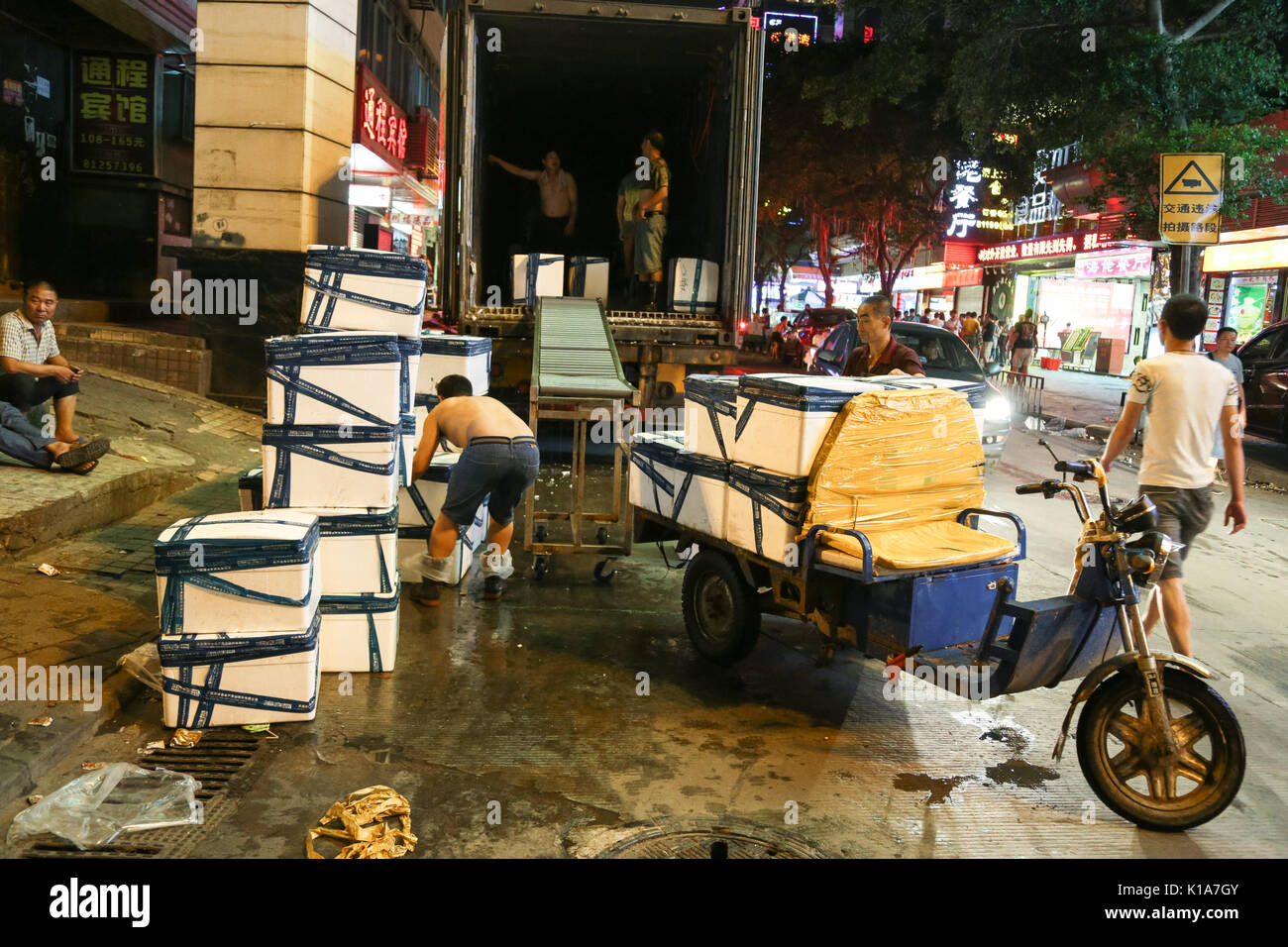 Arbeitnehmer entladen Meeresfrüchte Güter aus einem Container Anhänger an huangsha Seafood Handel Markt in Guangzhou, Guangdong, China. Stockfoto