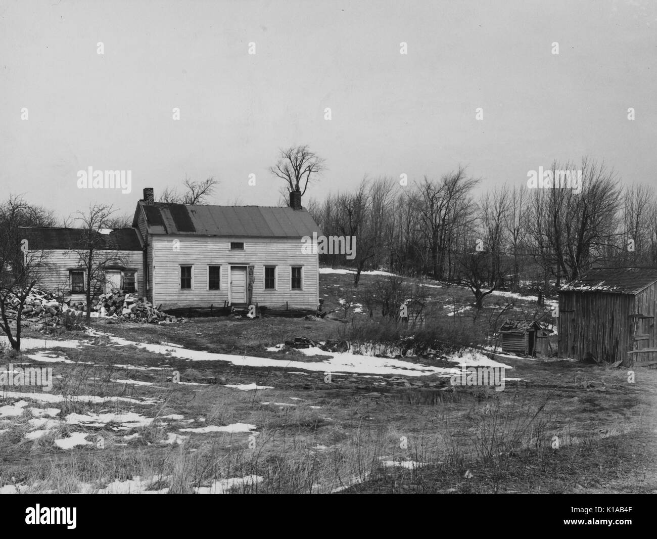 Ein heruntergekommenes Bauernhaus befindet sich auf einem teilweise viel Schnee bedeckt, auf einem Bauernhof optioned als Wild life, Remington, New York, 1936. Von der New York Public Library. Stockfoto