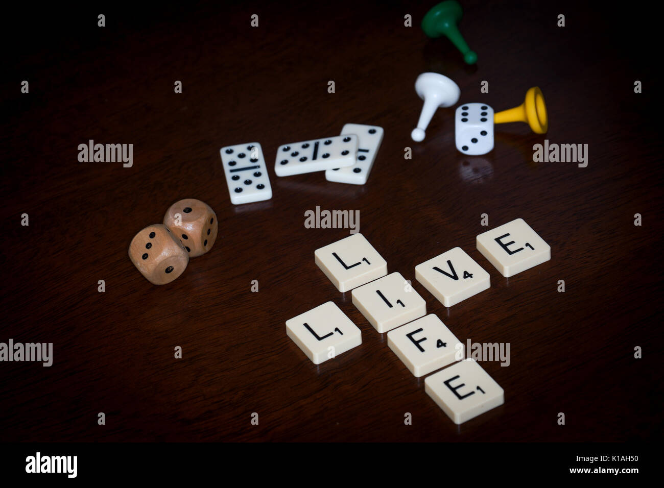 Wort Fliesen, buchstabieren Sie 'Leben', verschiedene Brettspiele Utensilien ist in der Nähe. Stockfoto