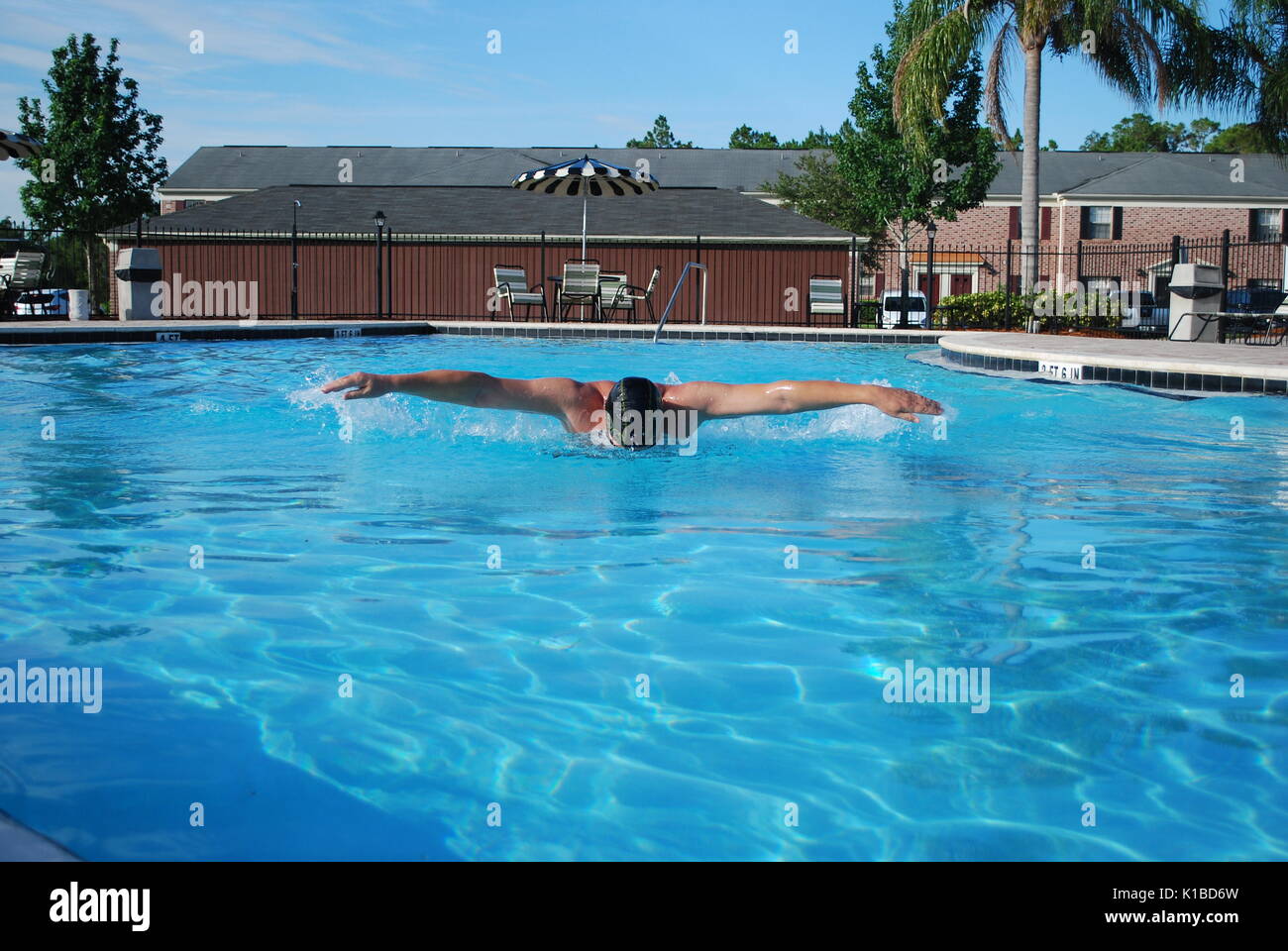 Professionelle Schwimmer Workout. Der Athlet üben butterfly Stil im Außen Swimmingpool mit blauen Wasser Farbe. Konzept der Stromversorgung Stockfoto