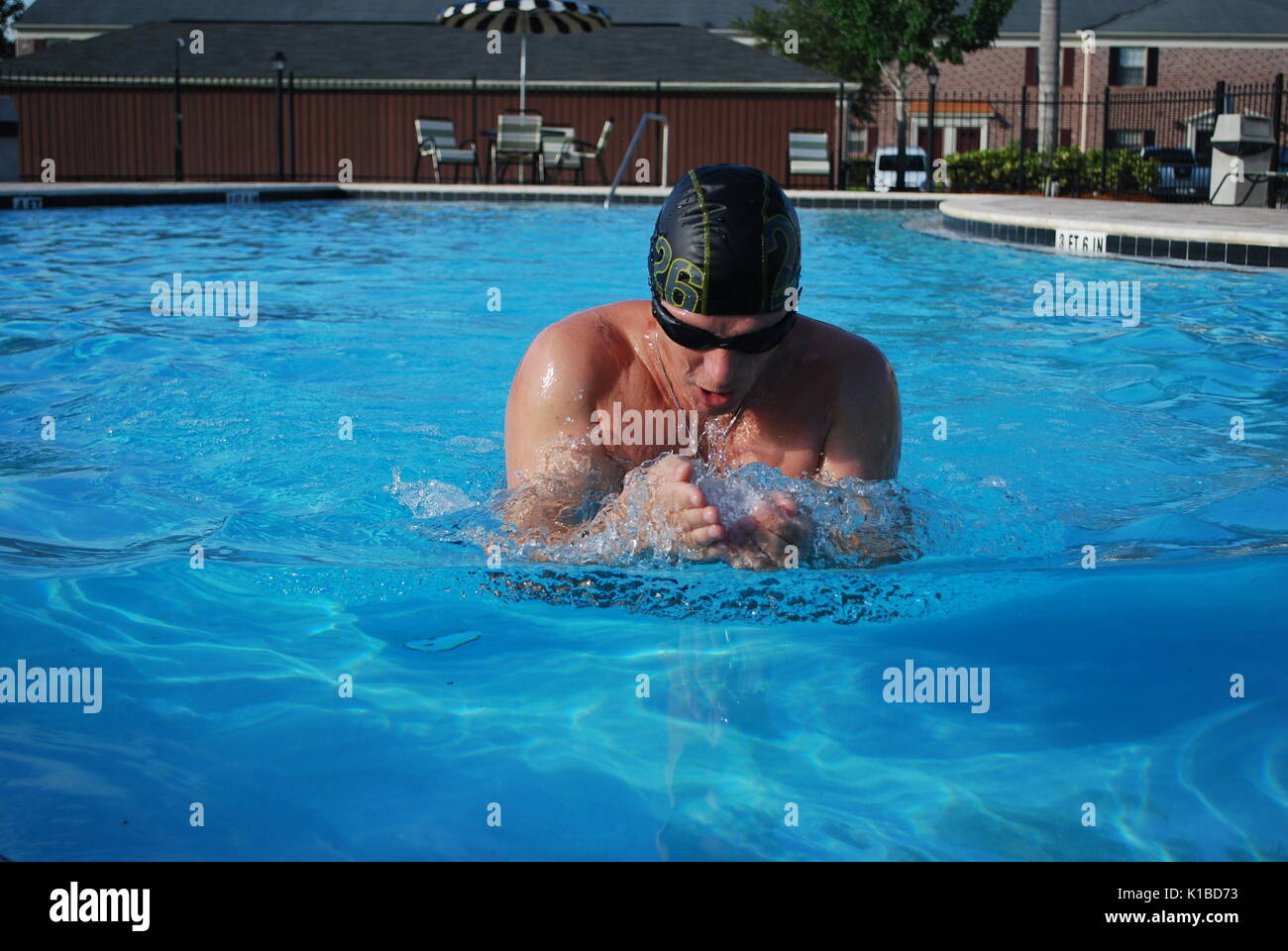 Professionelle Schwimmer an der Brust in der Nähe der Pool mit sehr blauen Wasser. Badekappe. Schwimmen Brille. Stockfoto