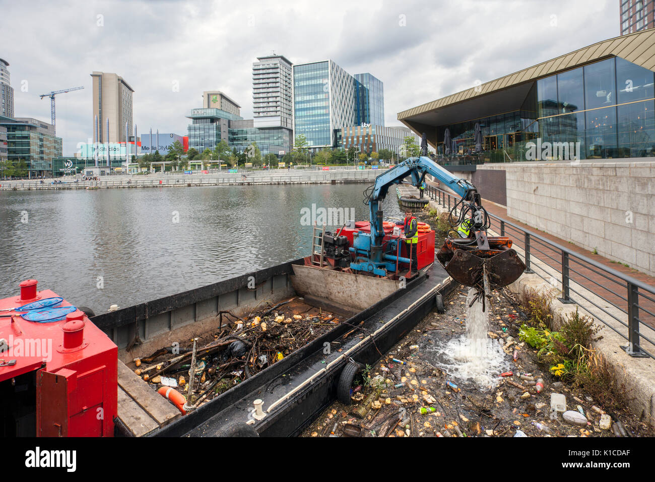 Müllsammelboot auf dem Manchester Ship Canal; HIAB auf einem Lastkahn, der weggeworfene Plastikmüll, Abfall, Abfall, verschmutzt, Verschmutzung, Polystyrol und giftiger Müll, der von den Ufern der Kanäle in Salford Quays and Trafford, Greater Manchester, England, entfernt wird. VEREINIGTES KÖNIGREICH Stockfoto