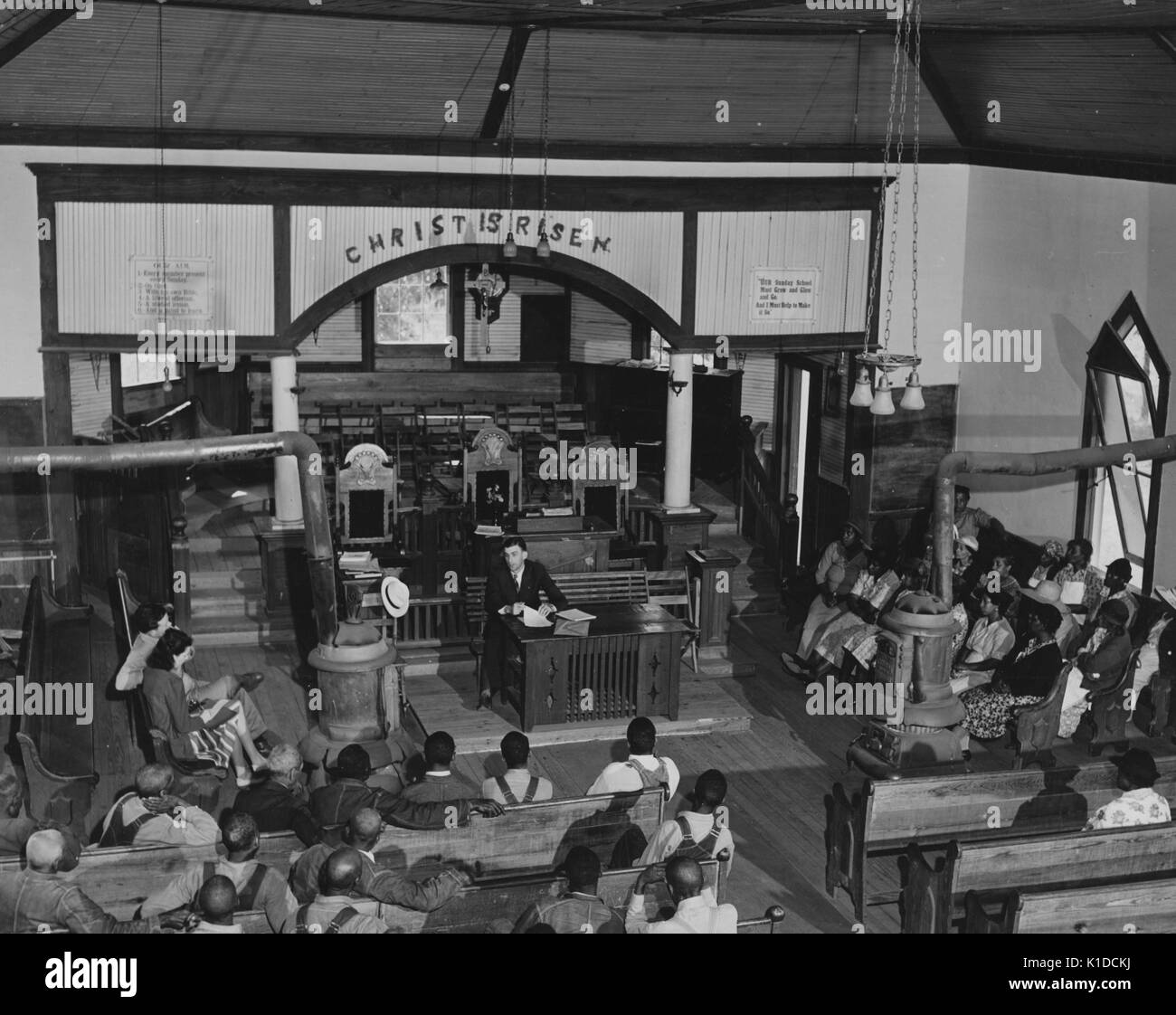 Afrikaner - Farm Security Administration Kreditnehmer in der Kirche sitzen und zuhören zu einem offiziellen, mit einer Meldung über dem Altar Christus ist auferstanden, 1920. Von der New York Public Library. Stockfoto