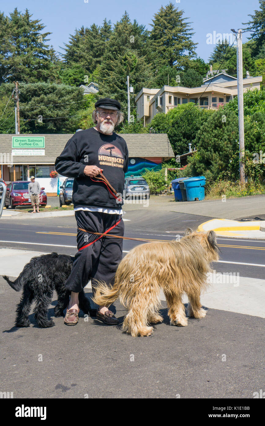 Senioren mit weißen Bart tragen schwarze Schirmmütze 2 Hunde in Yachats auf Oregon Coast Highway stoppt zu posieren in Leinen verwickelt wird Stockfoto
