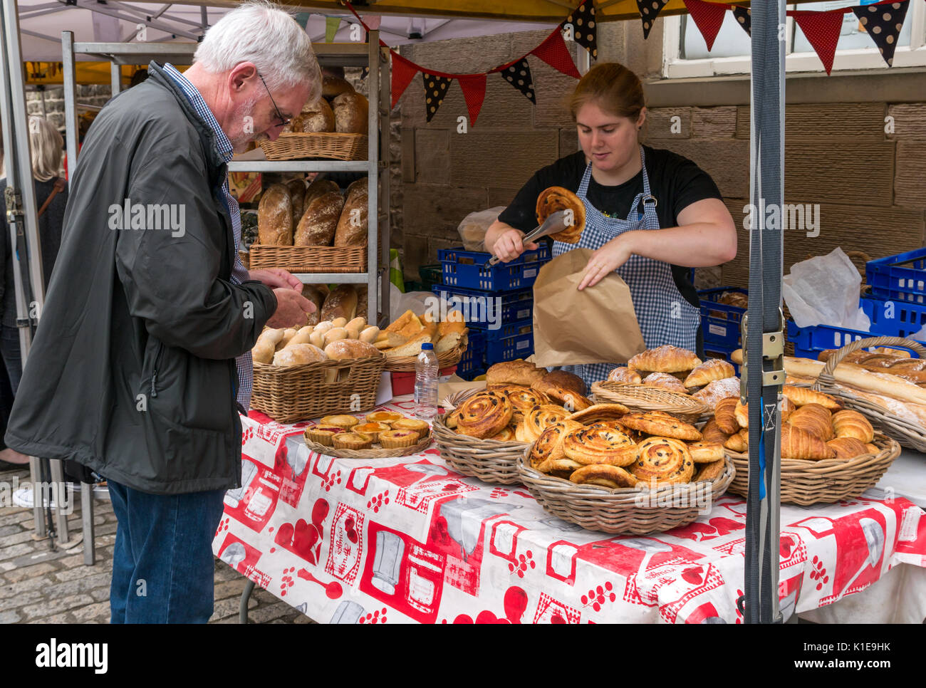 Dock Place, Leith, Edinburgh, Schottland, Großbritannien. Garküche in Leith Farmers Market, der findet jeden Samstag. Mann kaufen Pain au Raisin von Au Gourmand Brot Abschaltdruck Stockfoto