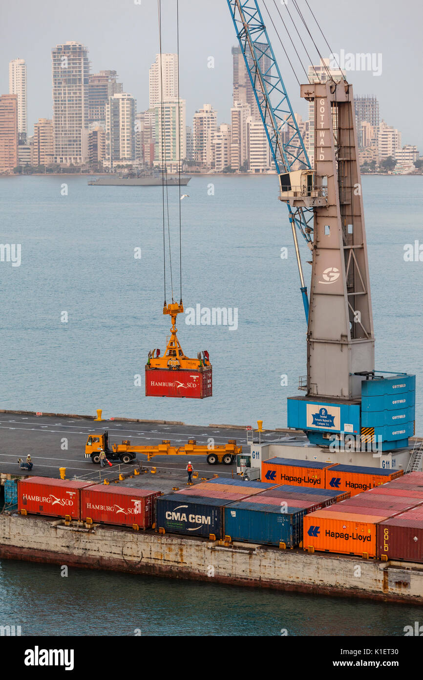 Cartagena, Kolumbien. Entladen von Containern im Hafen. Bocagrande Apartment Gebäude im Hintergrund. Stockfoto
