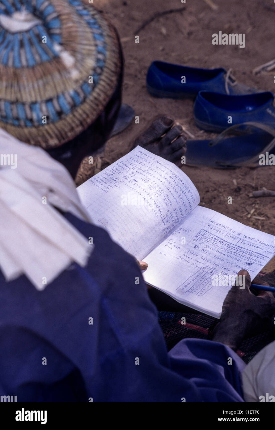 Niger, Doutouel Village, West Afrika. Notebook des Menschen an die Alphabetisierung von Erwachsenen Klasse. Stockfoto