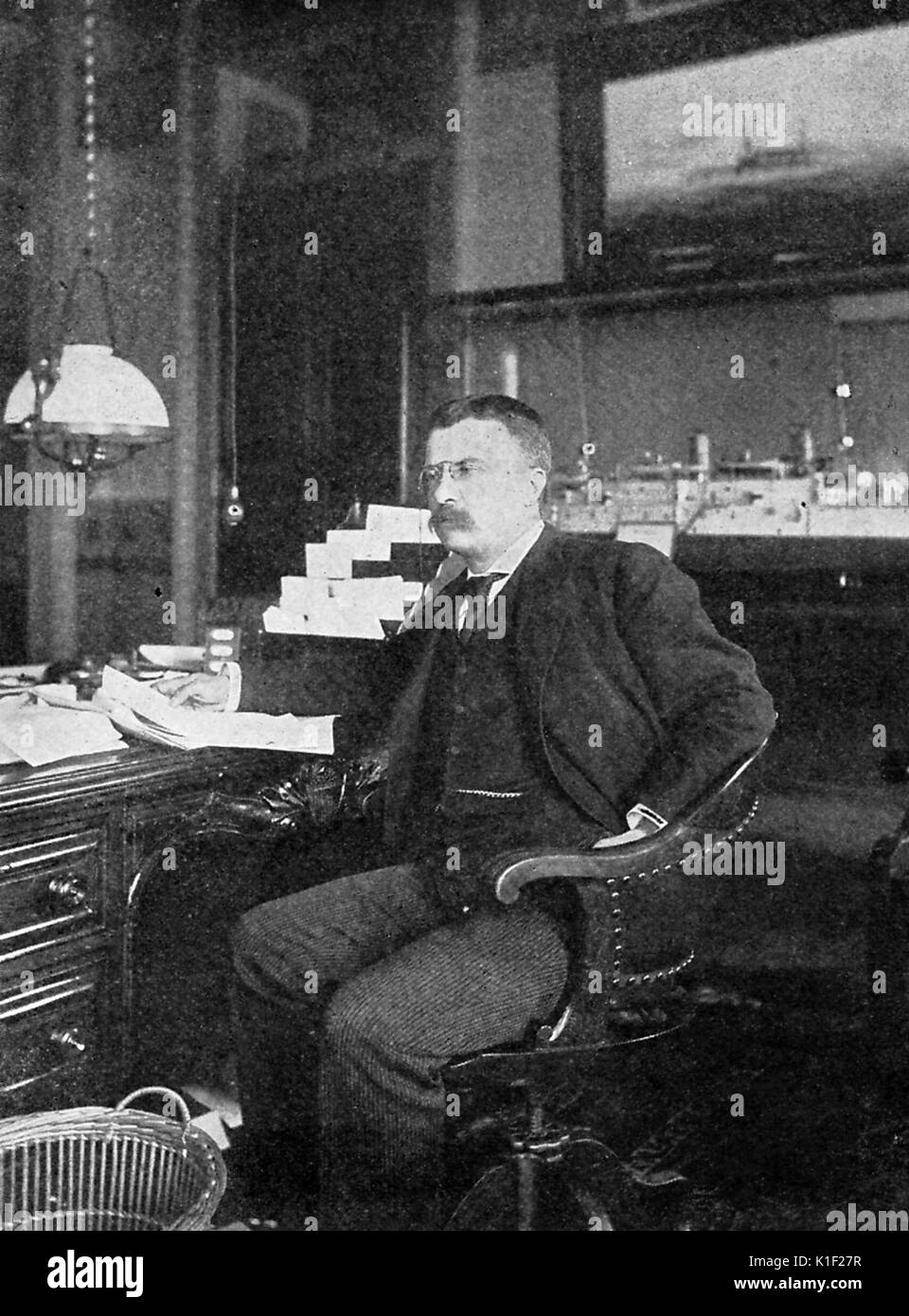 Portrait von Theodore Roosevelt als Stellvertretender Sekretär der Marine, an seinem Schreibtisch, Washington, DC, 1898 sitzen. Stockfoto