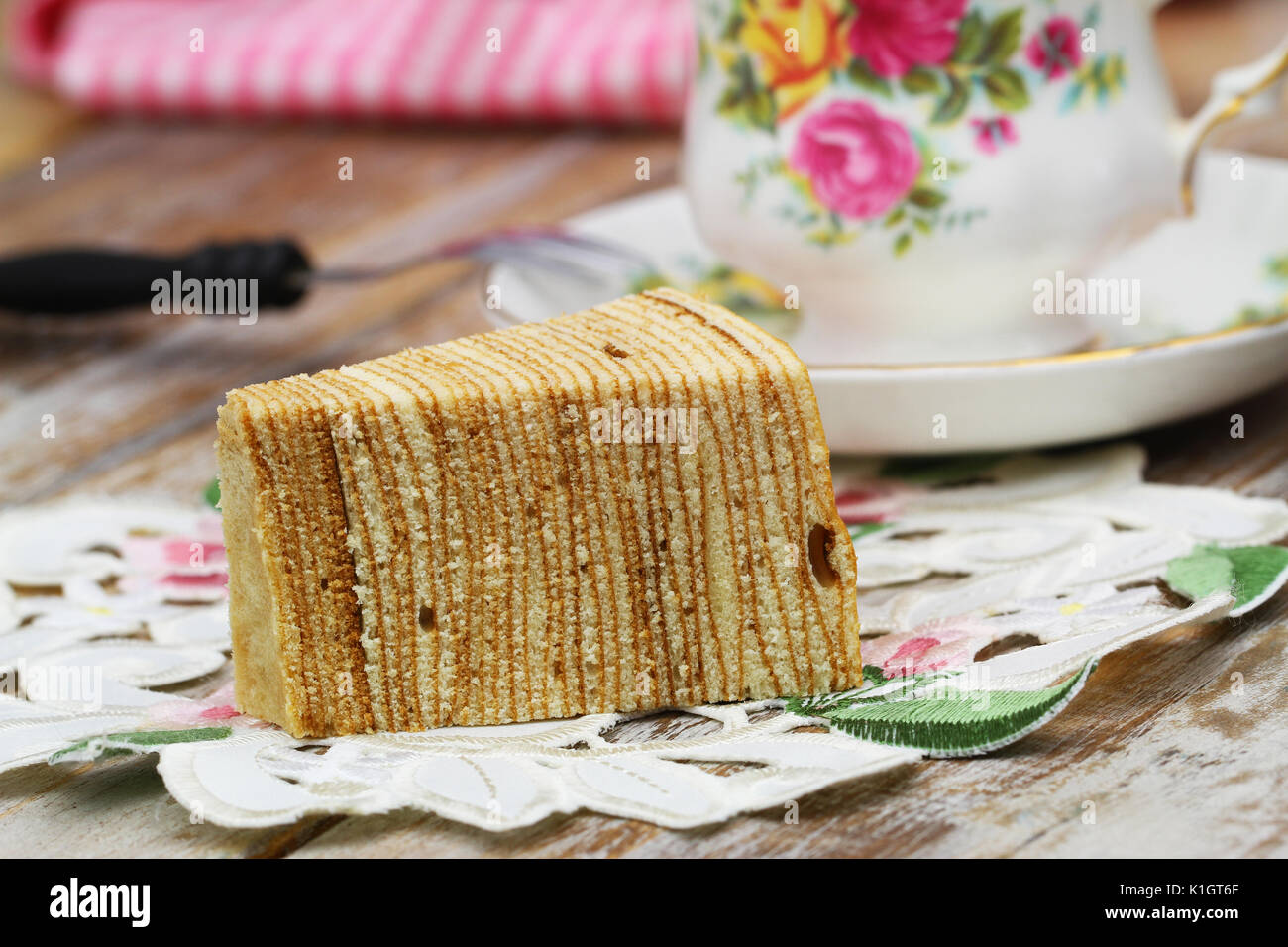 Sekacz, traditionelle polnische Biskuitboden auf Serviette mit Tasse Tee Stockfoto