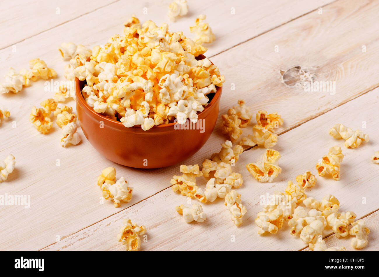 Käse Popcorn in eine braune Schale auf den Holztisch Stockfoto