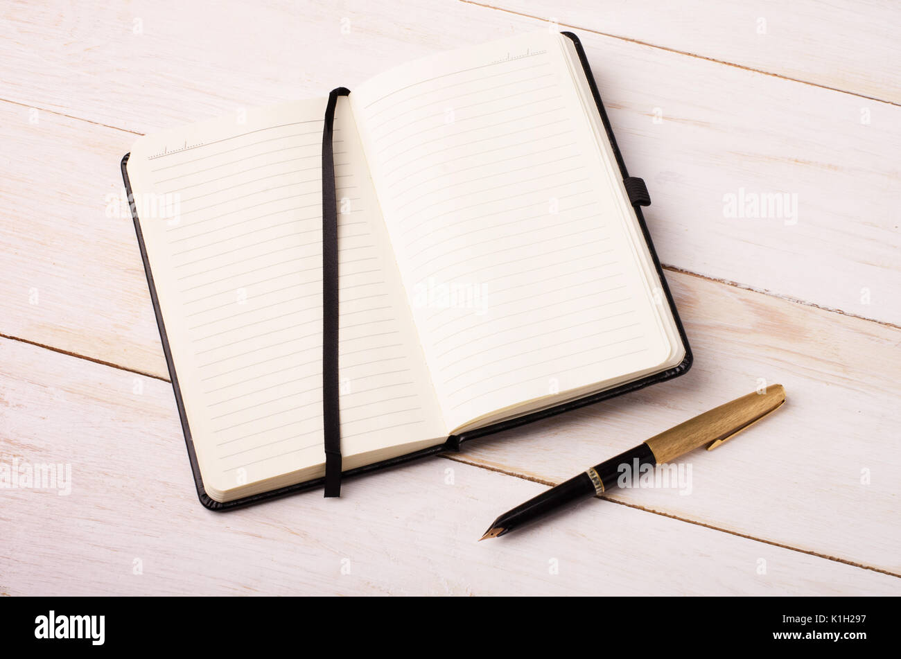 Notebook mit einem Stift auf ein weißes Holz- Tabelle öffnen. Business, Office oder Tagebuch Thema. Stockfoto