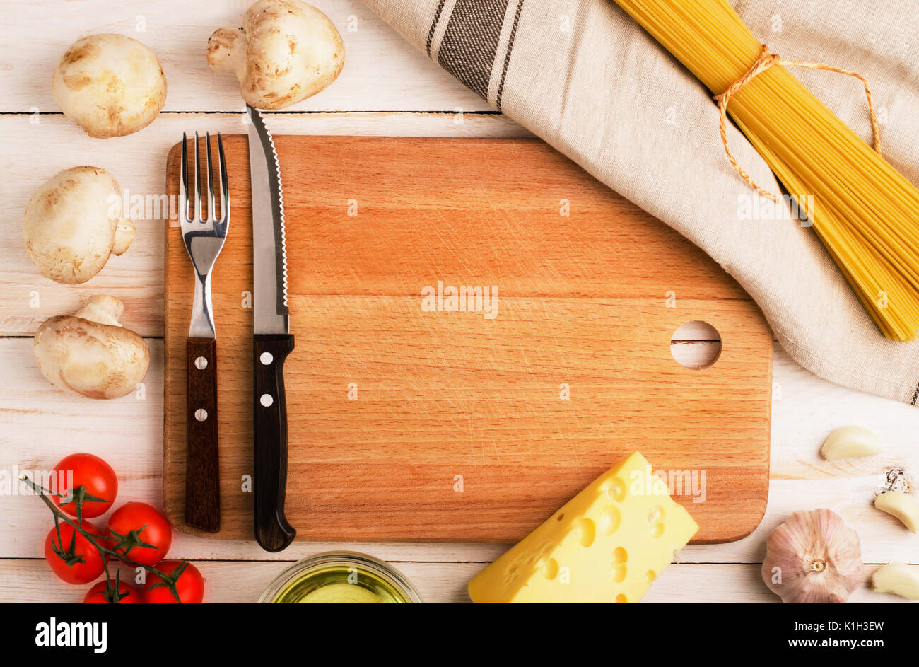 Trockene Pasta mit Gemüse, Pilzen, Käse und Tomaten auf rustikalen Hintergrund. Platz für Text Stockfoto