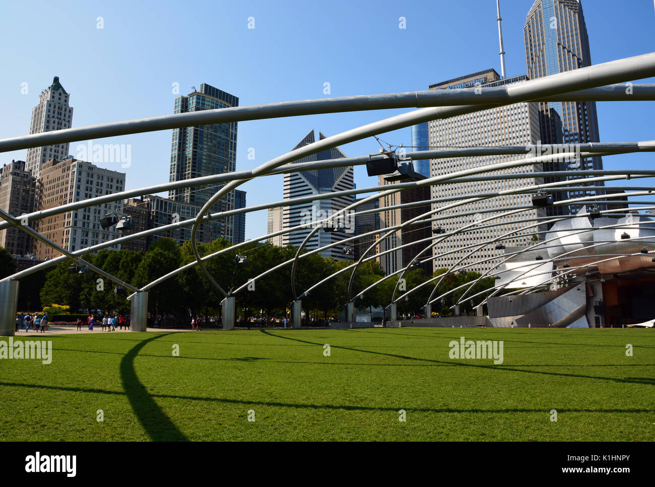 Der Rasen an den Jay pritzker Pavilion in Millennium Park, mit der Chicago Downtown Skyline oben auftaucht, ist ein beliebter Ort für Musik. Stockfoto