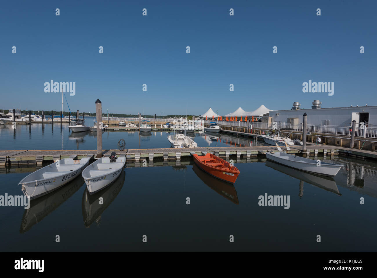 Belmar, NJ USA - August 26, 2017 Orange und Weiß Motorboote sind im Belmar Marina angedockt und im Wasser spiegelt. Redaktionelle Verwendung. Stockfoto
