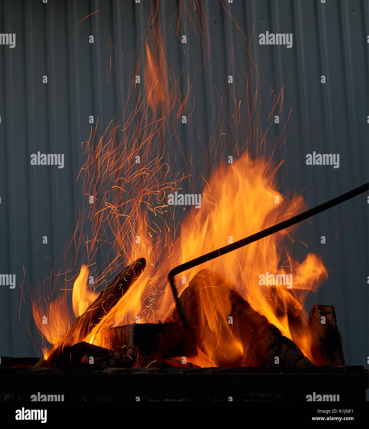 Rot und Orange knisterndes Feuer, die bei der Verbrennung von Holz in den Grill im Freien Stockfoto