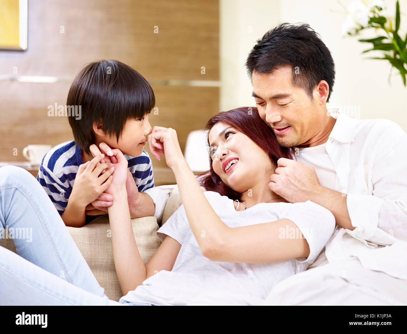 Jungen asiatischen Mutter und Vater sitzen auf der Couch zu Hause Spaß spielen mit Sohn. Stockfoto