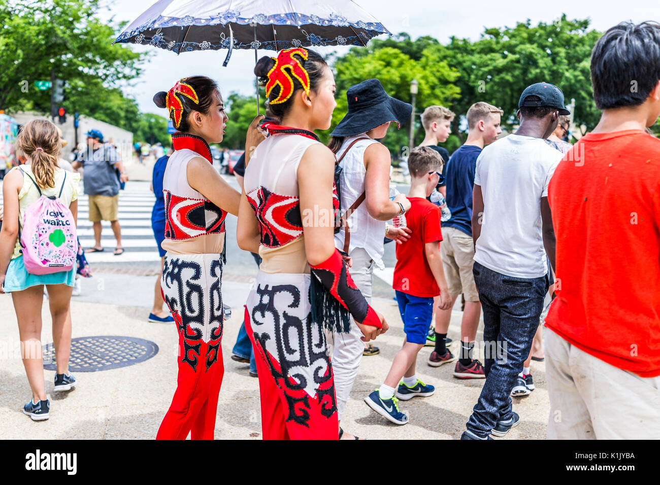 Washington DC, USA - Juli 3, 2017: Touristen warten Straße Straße auf der National Mall mit Nahaufnahme des chinesischen Mädchen mit Regenschirm zu Kreuz Stockfoto