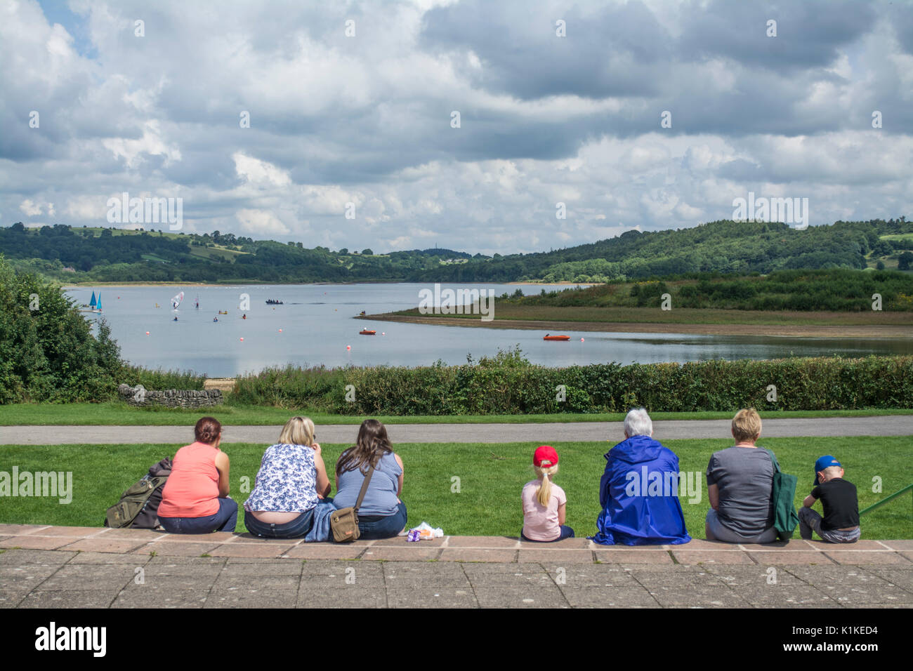 Besucher sitzen auf Schritte über den RESEVOIR an Carsington Water in Derbyshire, England, UK suchen Stockfoto