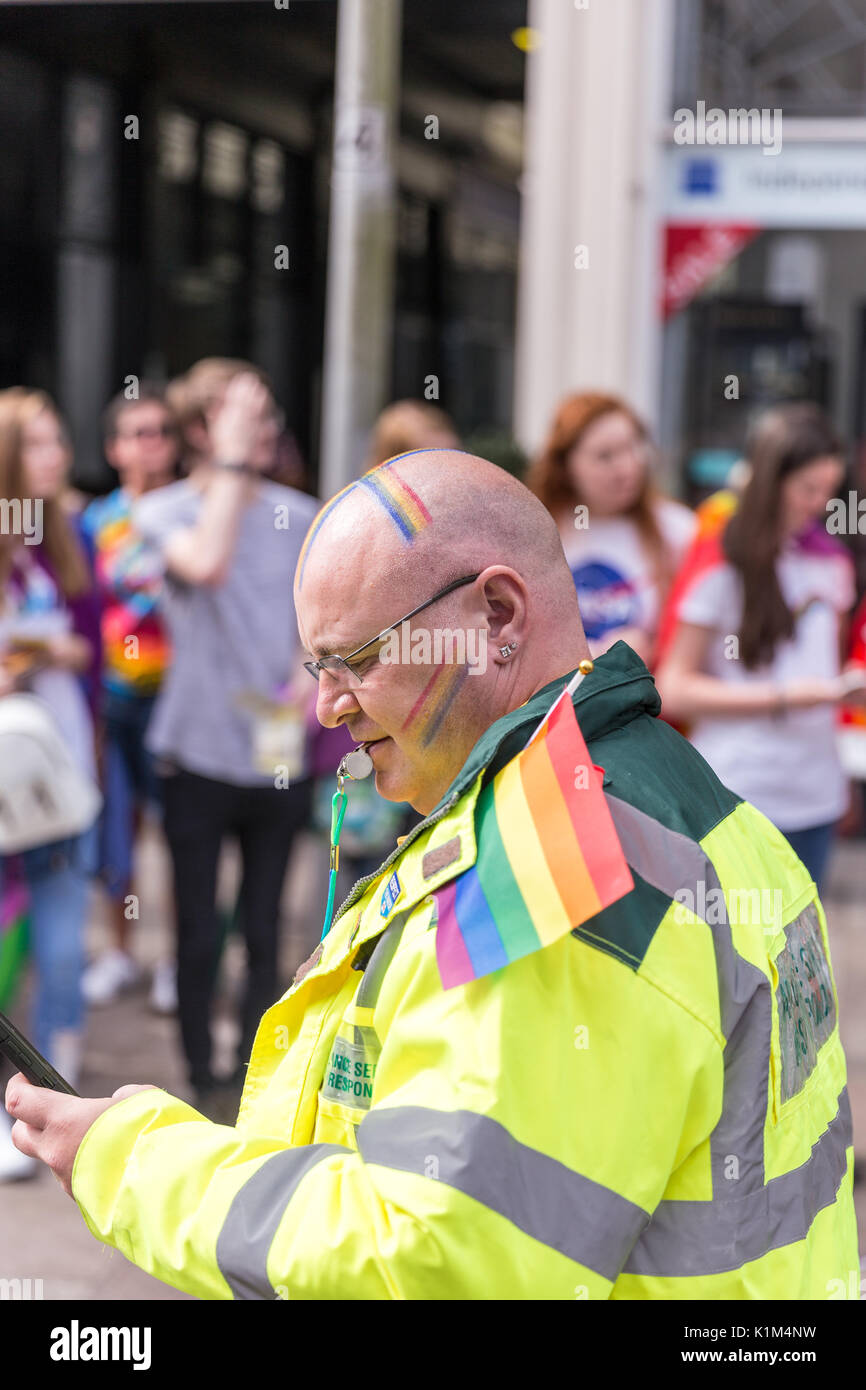 Ein Sanitäter trägt Regenbogen Gesicht Farbe an der Pride Parade, Cardiff 2017 Stockfoto