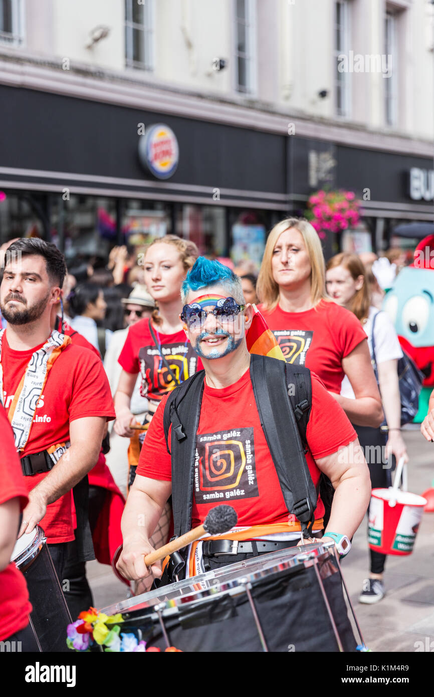 Ein Mann mit blauen Haaren und einer großen märsche Trommel in Cardiff Pride Parade 2017 Stockfoto
