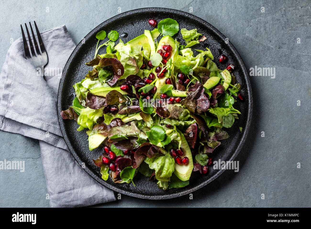 Blattsalat mit Granatapfel auf schwarze Platte, Schiefer-Hintergrund Stockfoto