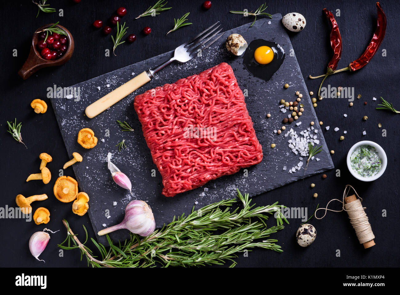 Gehackte oder Hackfleisch mit Kräutern, Beeren und Pfifferlingen. Restaurant kochen Konzept. Ansicht von oben. Stockfoto