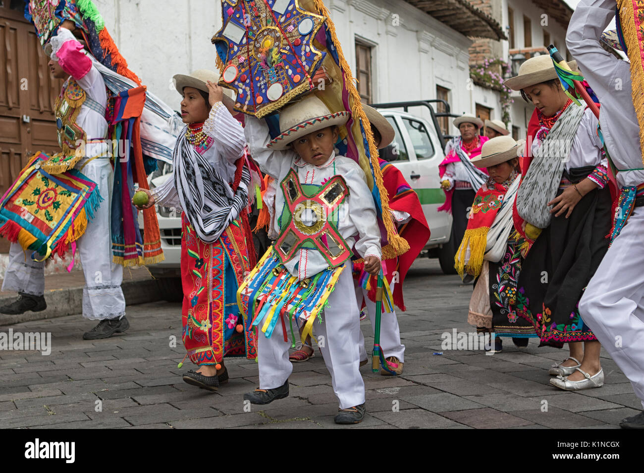 Juni 18, 2017 Pujili, Ecuador: junge Einheimische junge kichwa Kinder tragen bunte traditionelle Kleidung in Corpus Christi Parade tanzen auf der St Stockfoto