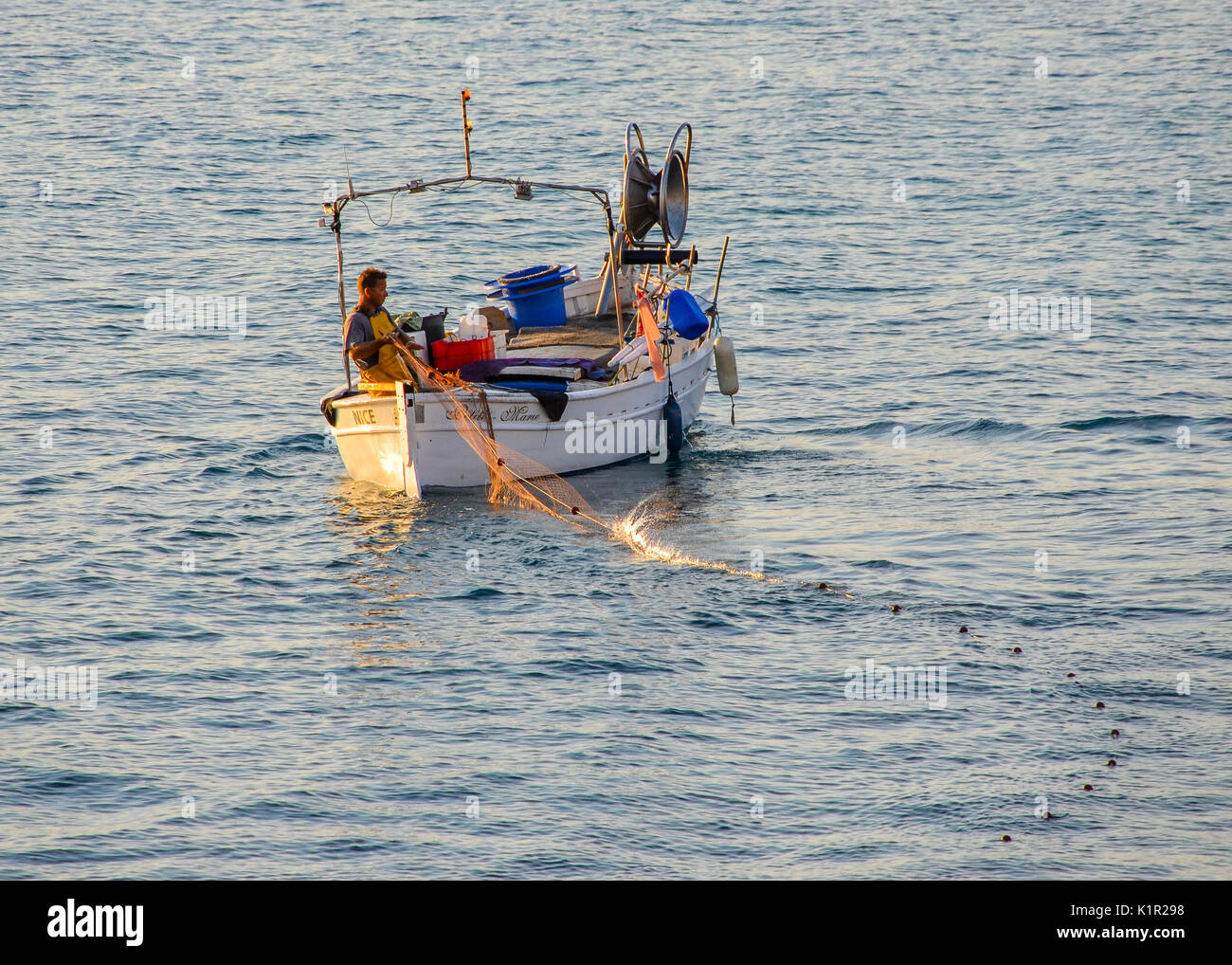Fischer mit Net auf dem Ozean in Cote d'Azur, Frankreich in der Morgendämmerung Stockfoto