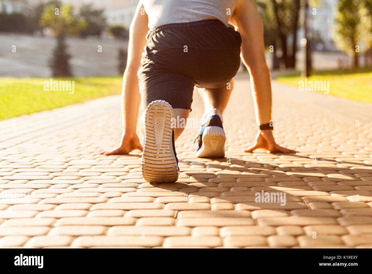 Runner im Park. Jungen athletischen Mann Joggen am Morgen. Niedrige Stern. Fitness Modell in crossfit Übung im Freien. Gesunder Lebensstil Konzept. Stockfoto