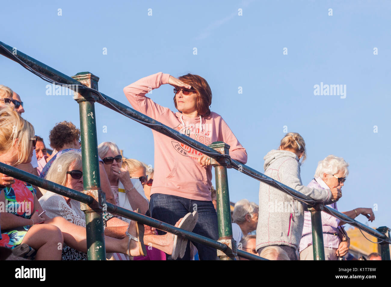 Eine Frau blickt in die Entfernung mit der Hand Ihre Augen zu schützen. Stockfoto