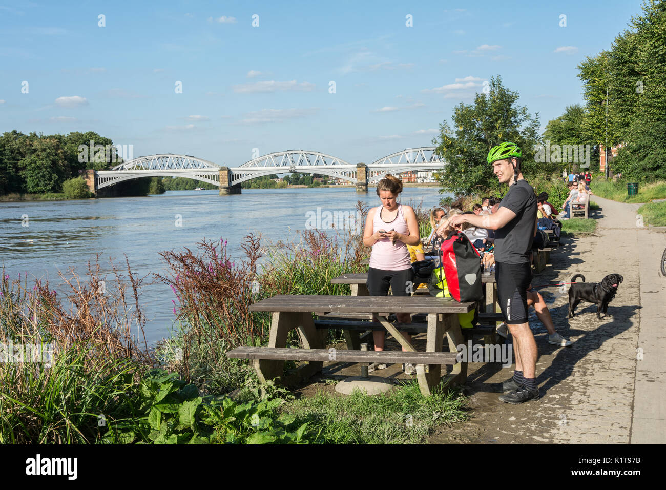 Die Menschen genießen einen Drink, in der Nähe der Themse, außerhalb der White Hart Pub in Barnes, London, SW13, UK. Stockfoto