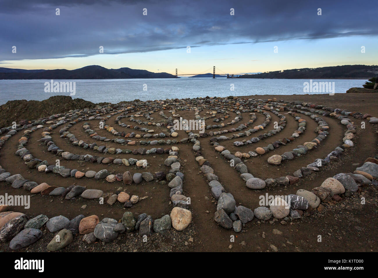 Mann aus Rock Labyrinth Herausforderungen Wanderer auf verlassenen Strand Stockfoto