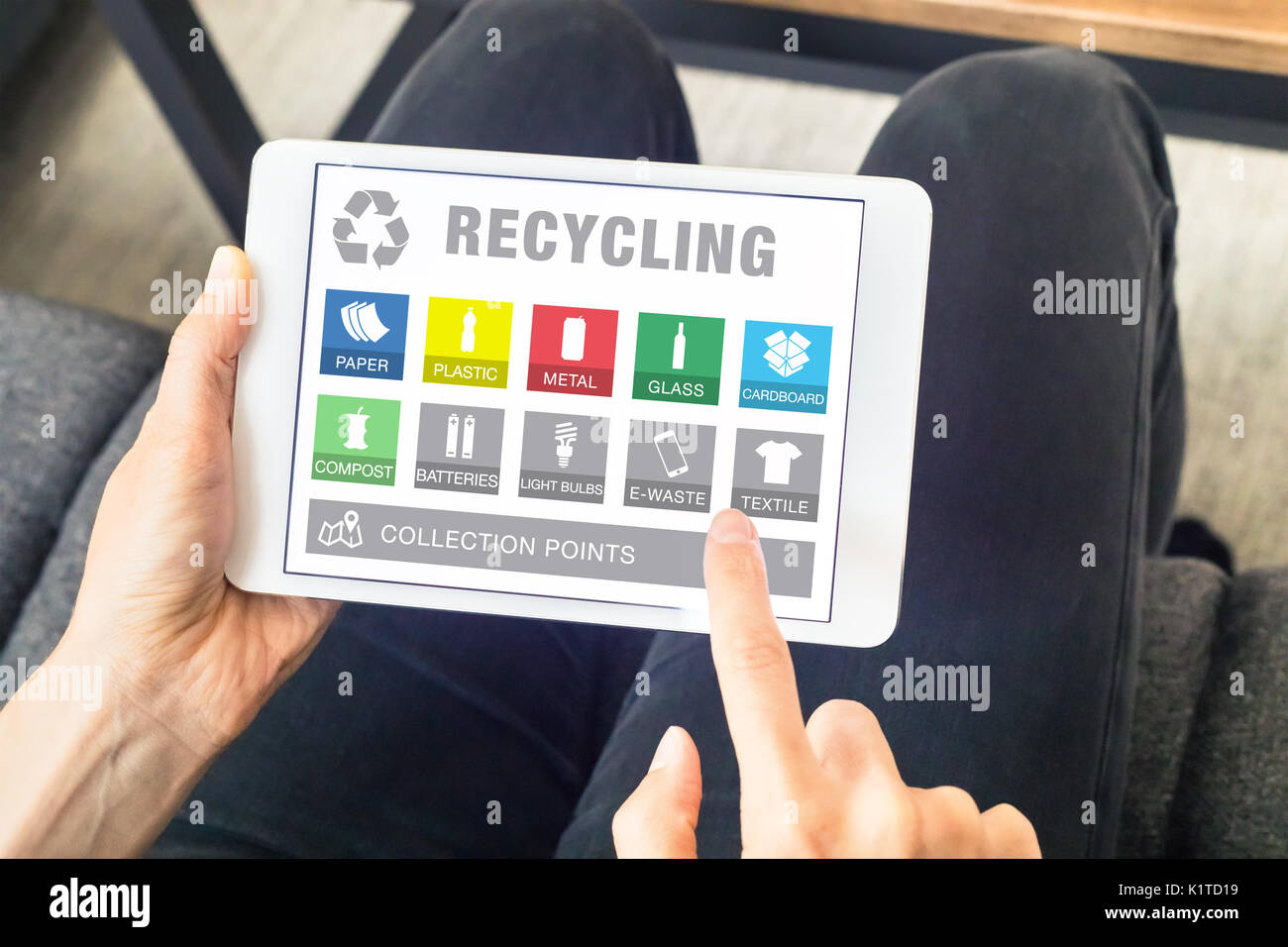 Person mit digitalen Tablet Computer mit App-Webseite für die Sortierung von Wertstoffen und Abfällen (Symbole aus Papier, Kunststoff, Metall, Glas, Flasche, e-waste Stockfoto
